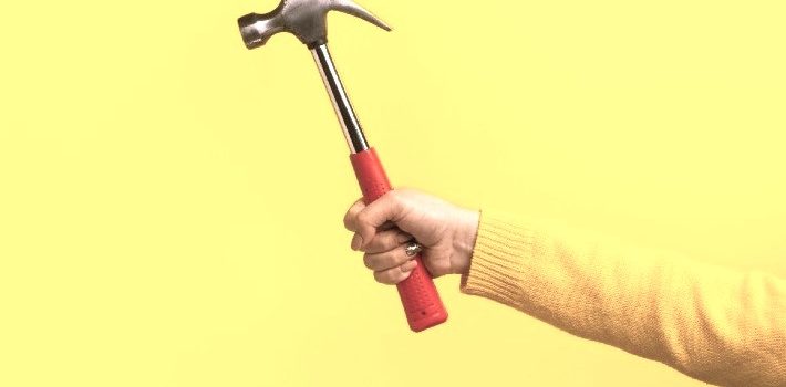 Man with a curved claw hammer in hand and ready for use
