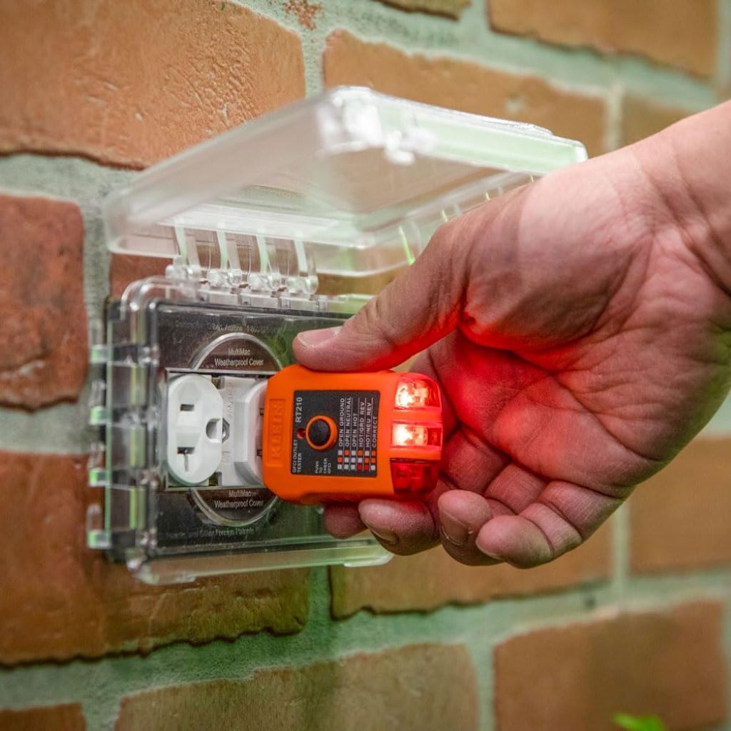 Electrician using Klein Tools NCVT1XTKIT to check outlets and ensure safe wiring.