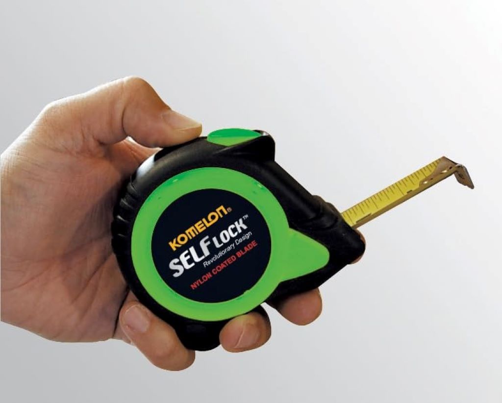 Close-up of Komelon SL2825 Self-Lock 25ft tape measure extended for precision