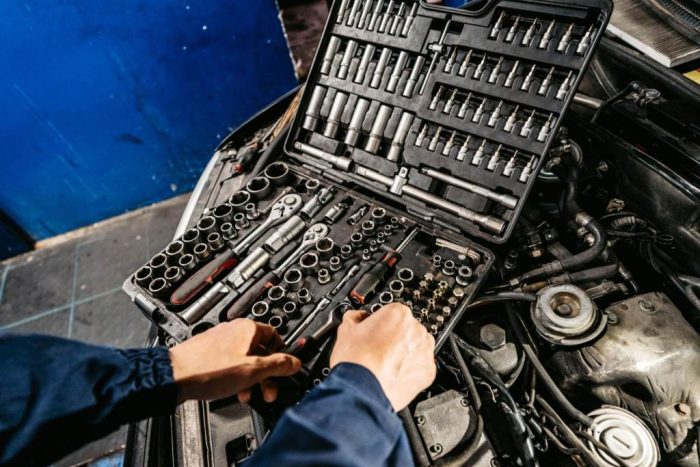 Auto mechanic using repairing car with Socket wrenches