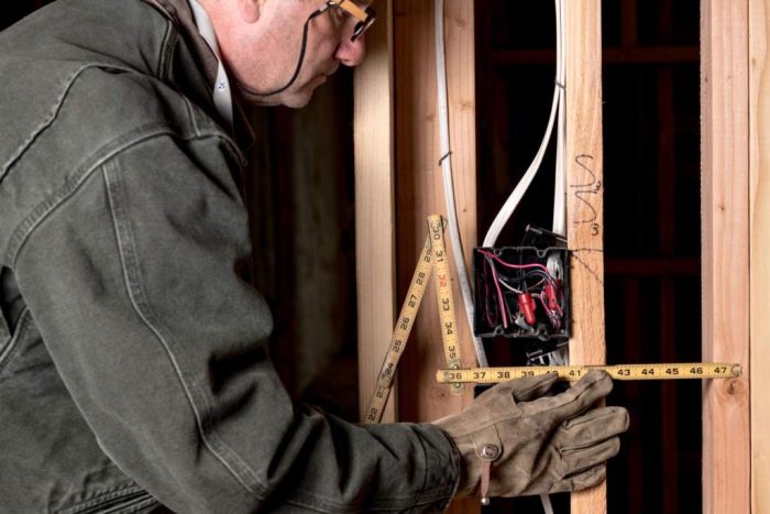 Construction worked measures the distance between studs