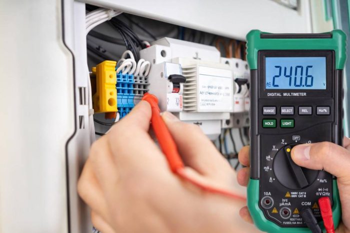 Technician Testing Voltage with Digital Multimeter