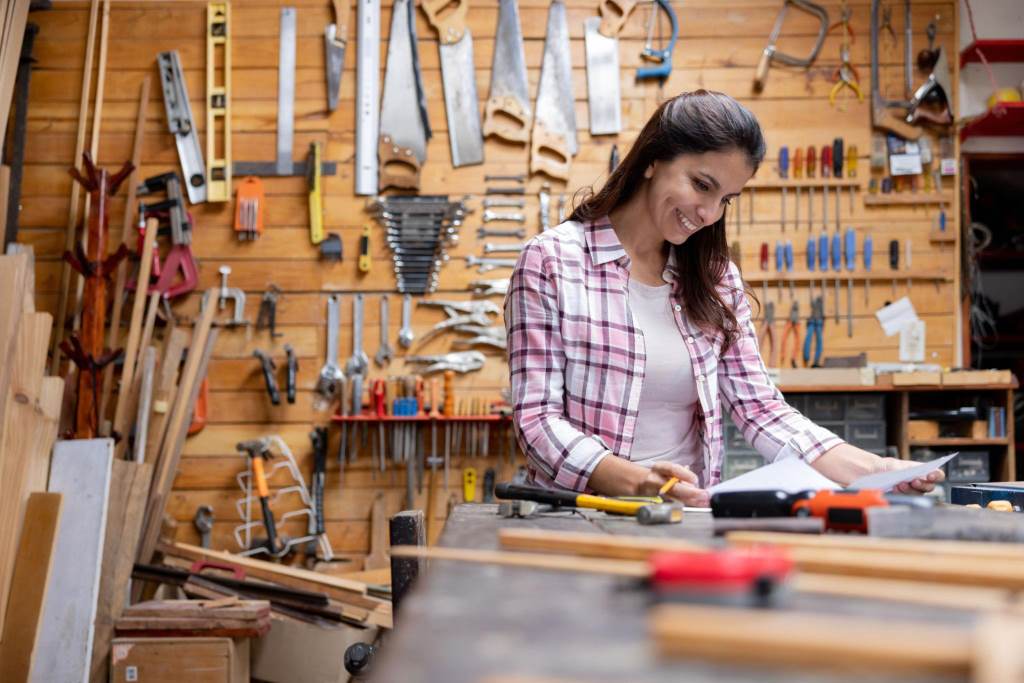 Woman using cordless drill for home DIY project