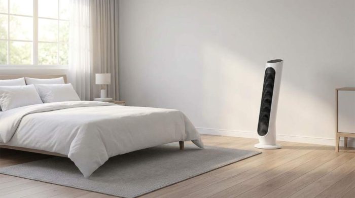 Tower fan positioned near an open bedroom window
